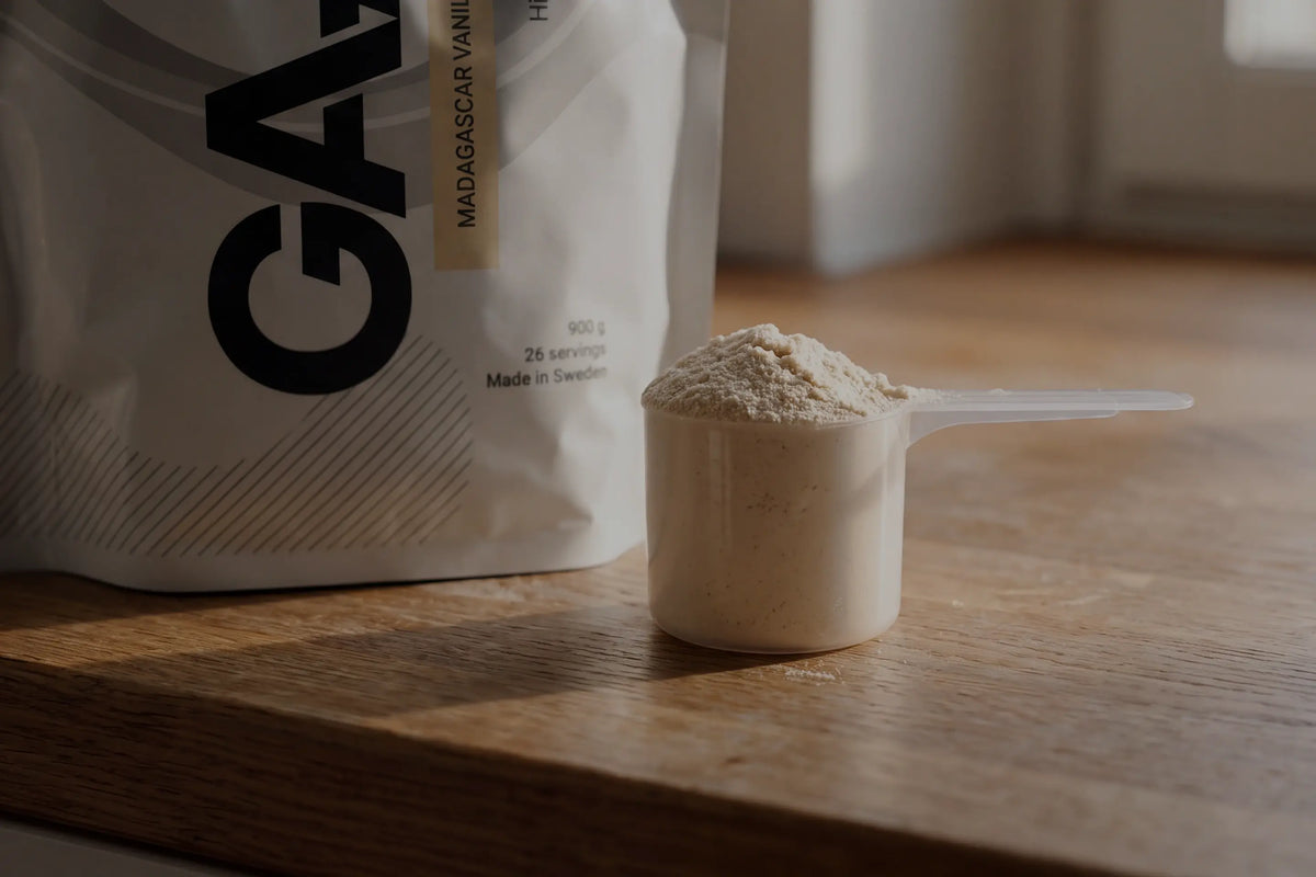 Skopa med proteinpulver från GAAM på ett träbord, ett praktiskt proteintillskott vid viktminskning