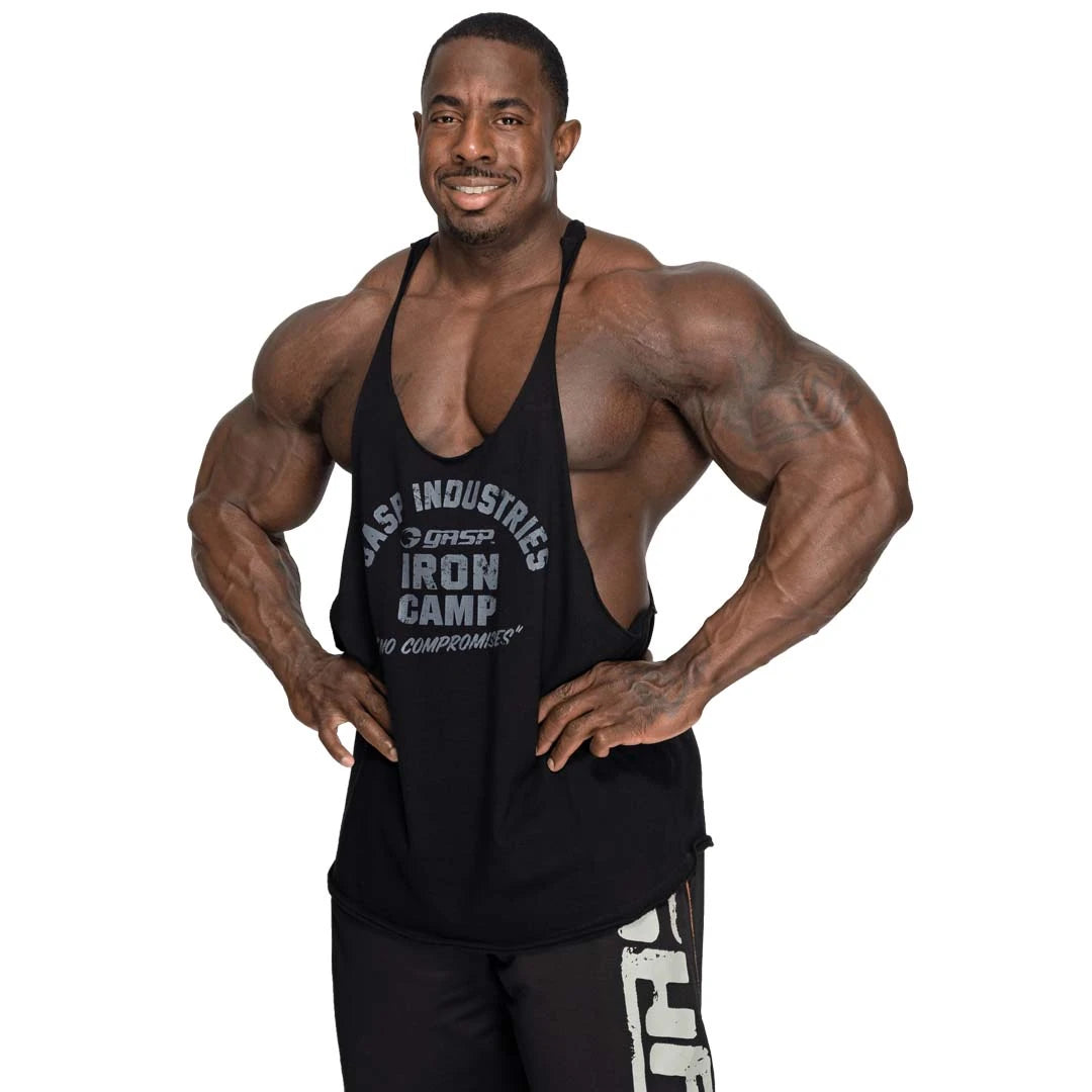 GASP Stringer Tank Black on musta puuvillainen treenitoppi suurella rintapainatuksella lihaksikkaan mallin yllä.
