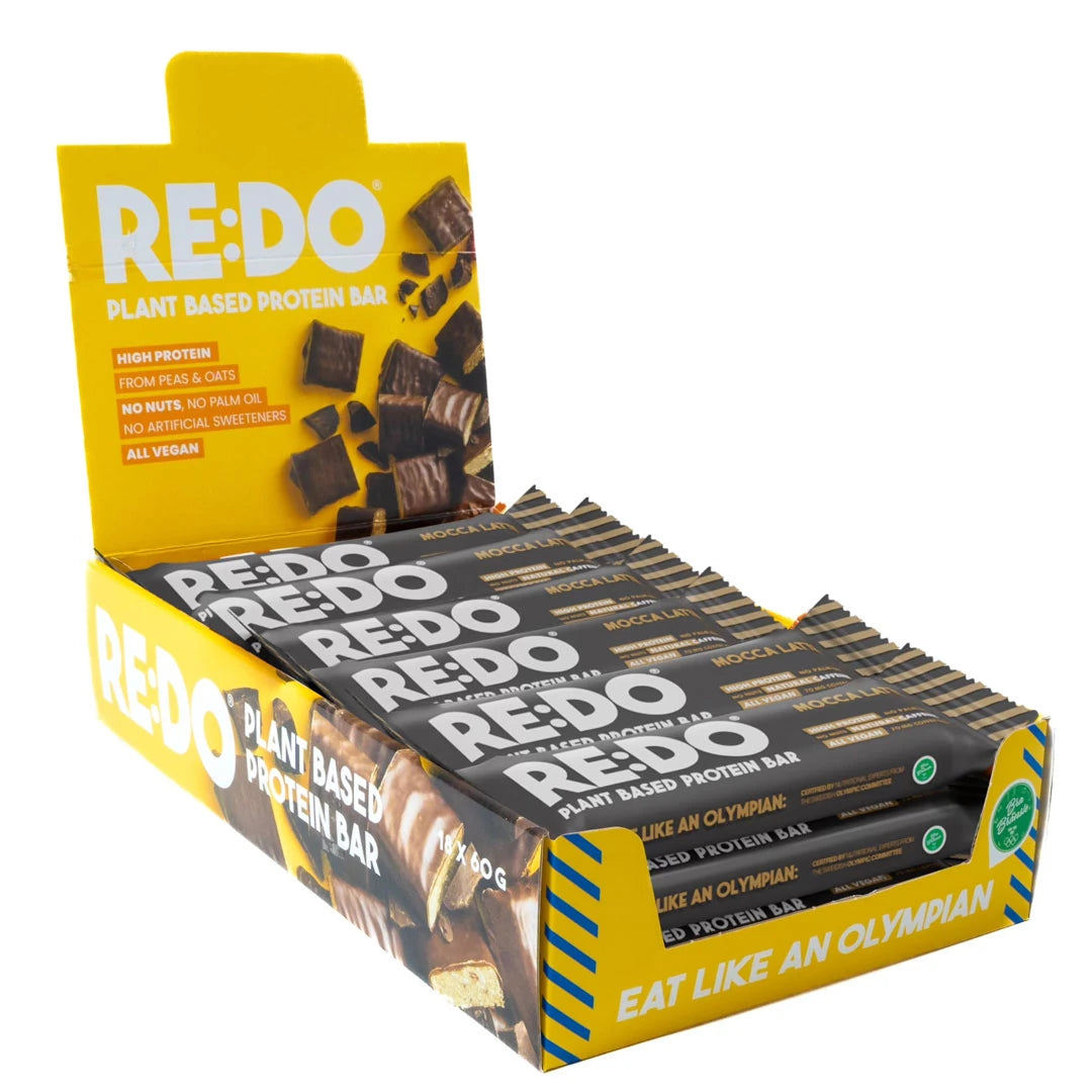 18 x REDO Koffein Bar 60 g keltaisessa laatikossa, joka on täytetty tummilla Mocca Latte -proteiinipatukoilla., kuva 1/1