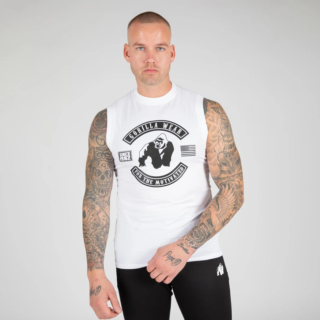 Gorilla Wear Tulsa Tank Top White, valkoinen puuvillainen hihaton paita isolla mustalla rintapainatuksella mallin yllä., kuva 2/8