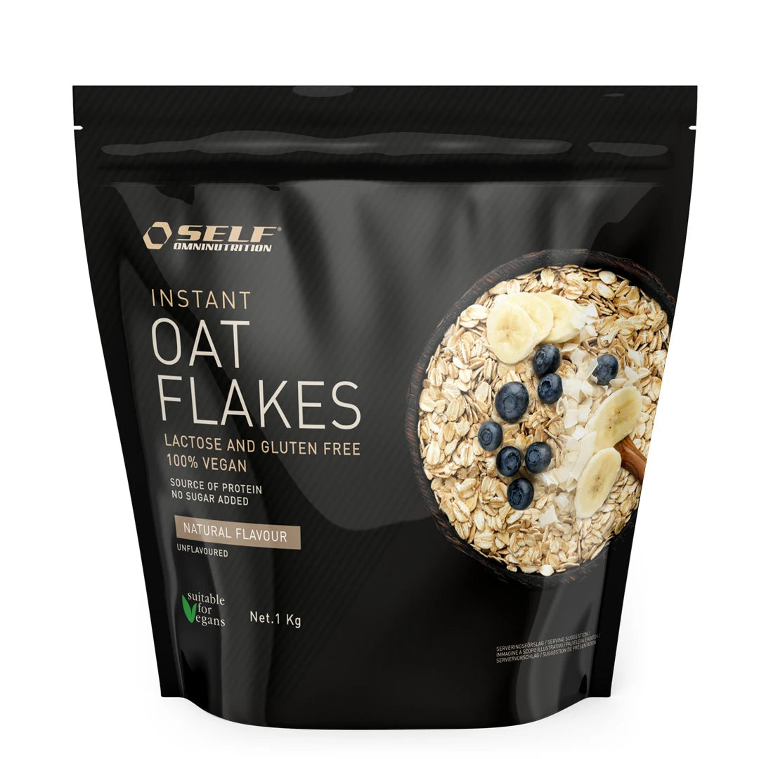 Self Omninutrition Instant Oat Flakes 1 kg pakattuna mustaan pussiin, jossa on kuva kaurahiutalekulhosta ja marjoista.