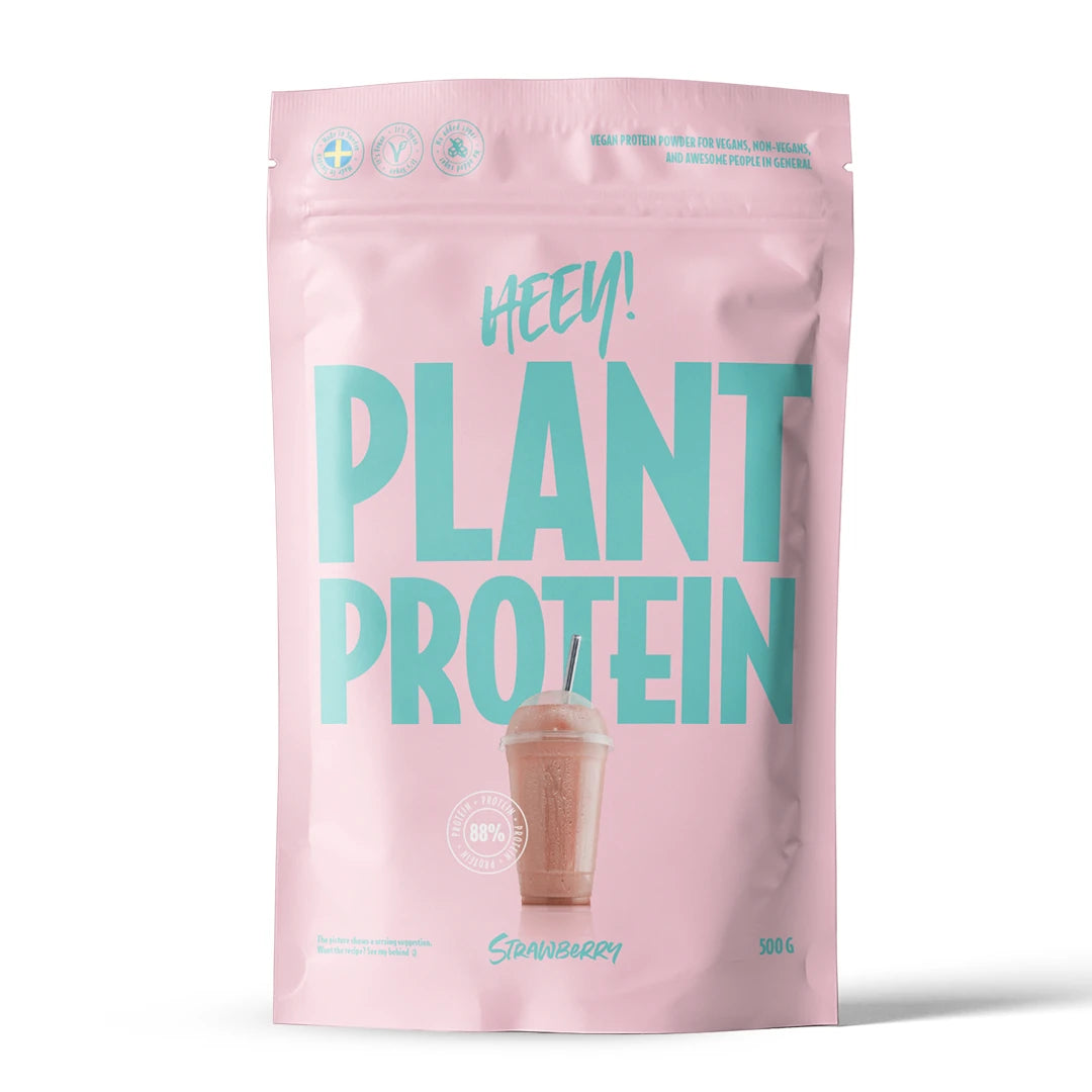 Heey! Vegaaninen proteiini 500 g -proteiinijauhe vaaleanpunaisessa pussissa turkoosilla tekstillä, makuna mansikka.