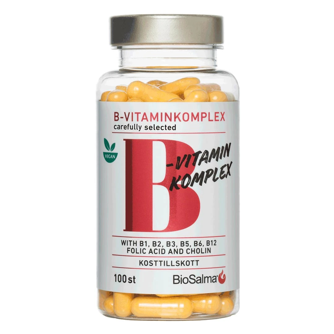 BioSalma B-vitamin Komplex 100 caps läpinäkyvässä purkissa, jossa on hopeakansi, valkoinen etiketti ja keltaiset kapselit.