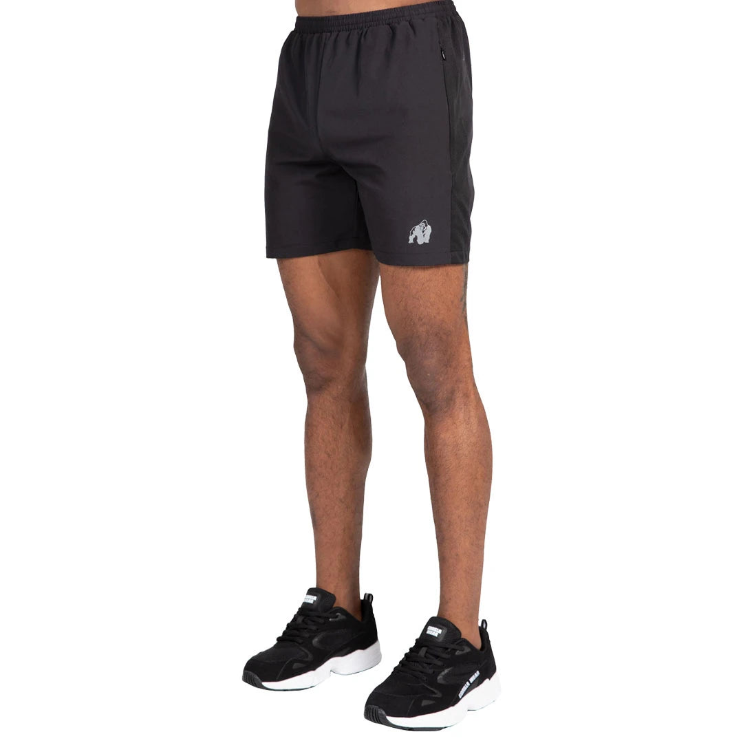 Gorilla Wear Lubec Shorts Black mallin yllä, mustat treenishortsit piilotaskuilla ja heijastavalla logolla.
