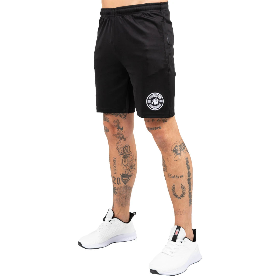Gorilla Wear Vernon Track Shorts Black, mustat joustavat treenishortsit, joissa on valkoinen logo vasemmassa lahkeessa., kuva 1/7