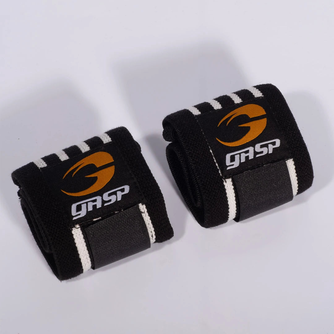Mustat GASP Hardcore Wrist Wraps Black/White -rannetuet joustavaa kangasta oranssilla logolla.