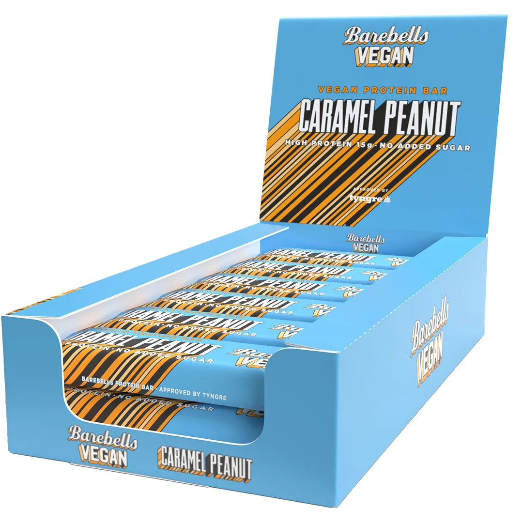 12 x Barebells Vegan Protein Bar 55 g Caramel Peanut vaaleansinisessä esittelylaatikossa oransseilla ja ruskeilla yksityiskohdilla.