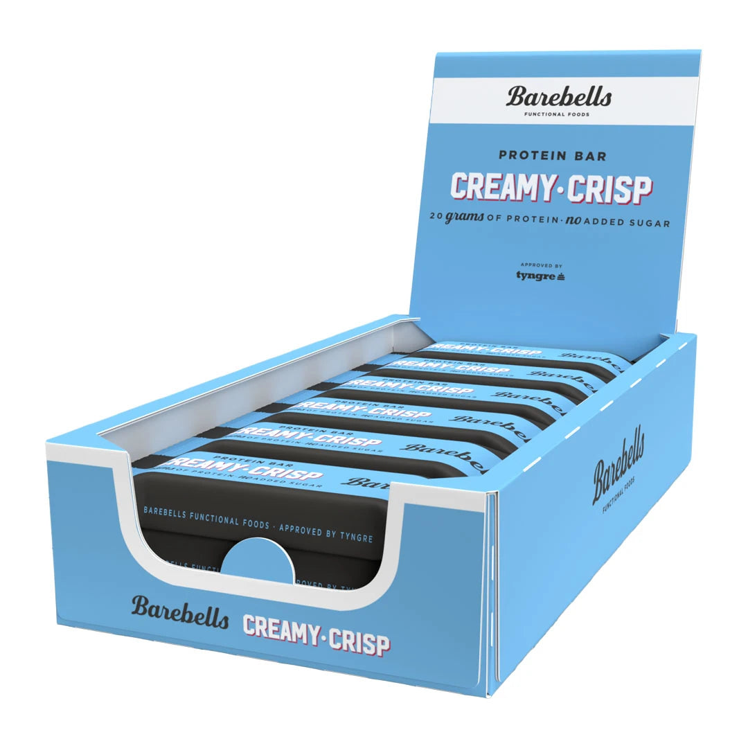 12 x Barebells Protein Bar 55 g Creamy Crisp vaaleansinisessä laatikossa, joka on täytetty mustilla ja sinisillä proteiinipatukoilla.