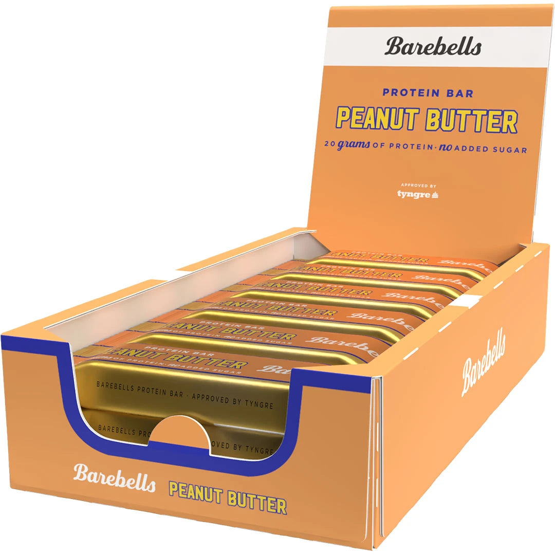 12 x Barebells Protein Bar 55 g Peanut Butter oranssi-valkoisessa esittelylaatikossa täynnä kultaisia proteiinipatukoita.