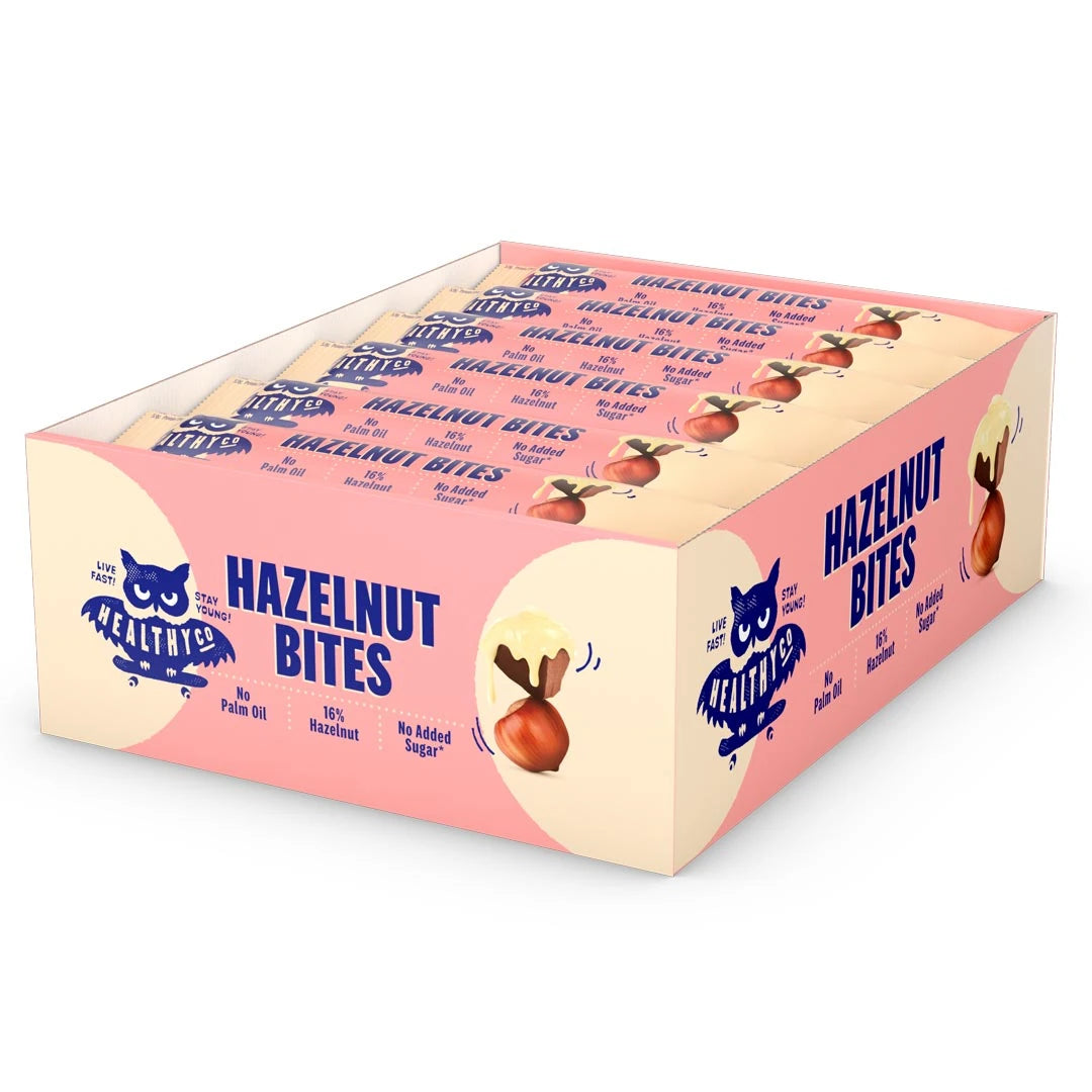 18 x HealthyCo Hazelnut Bites 21 g vaaleankeltaisessa ja vaaleanpunaisessa laatikossa täynnä suklaapaloja., kuva 1/1