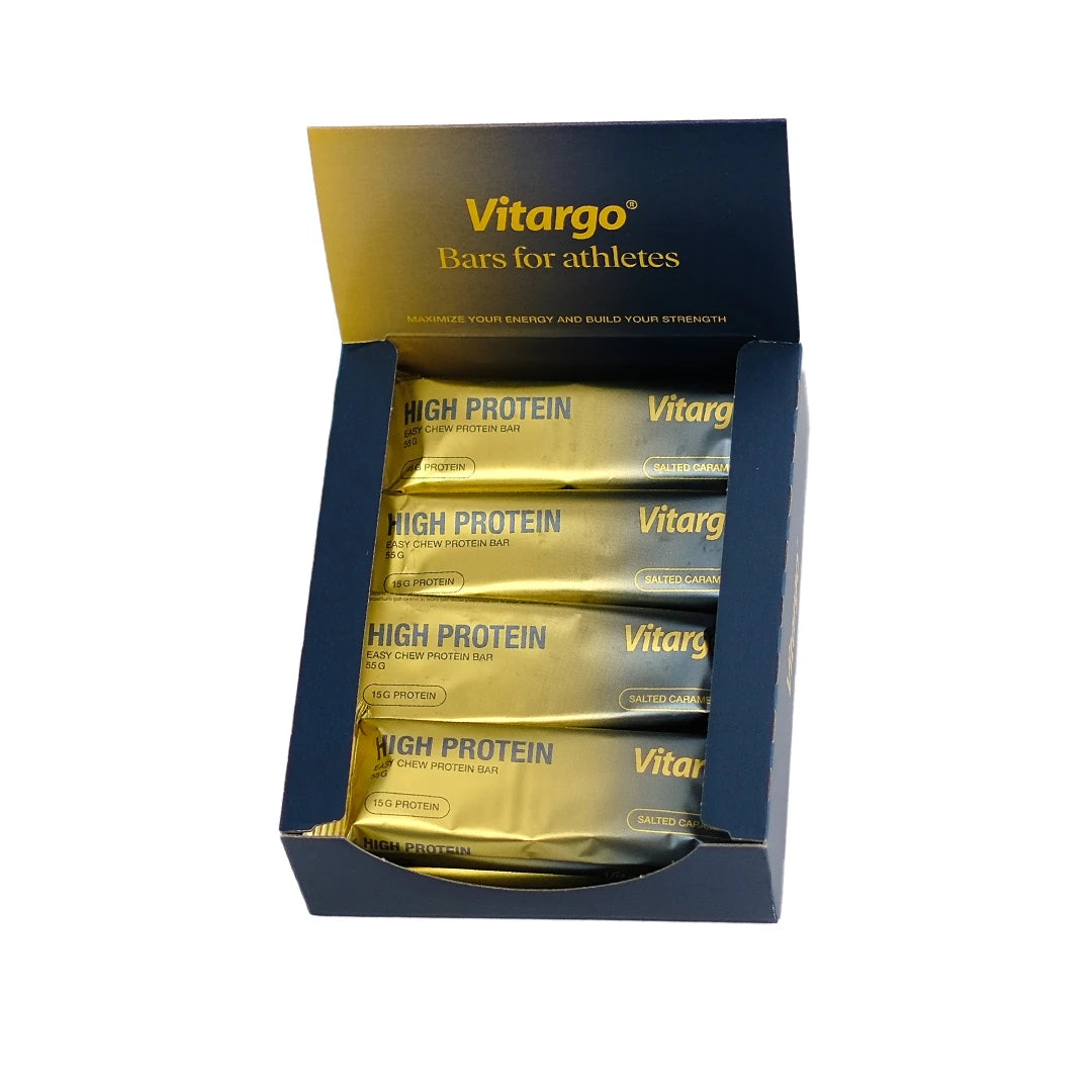 12 x Vitargo High Protein Bar 55 g tummansinisessä laatikossa, jossa on kultaisia Salted Caramel -makuisia proteiinipatukoita., kuva 1/1