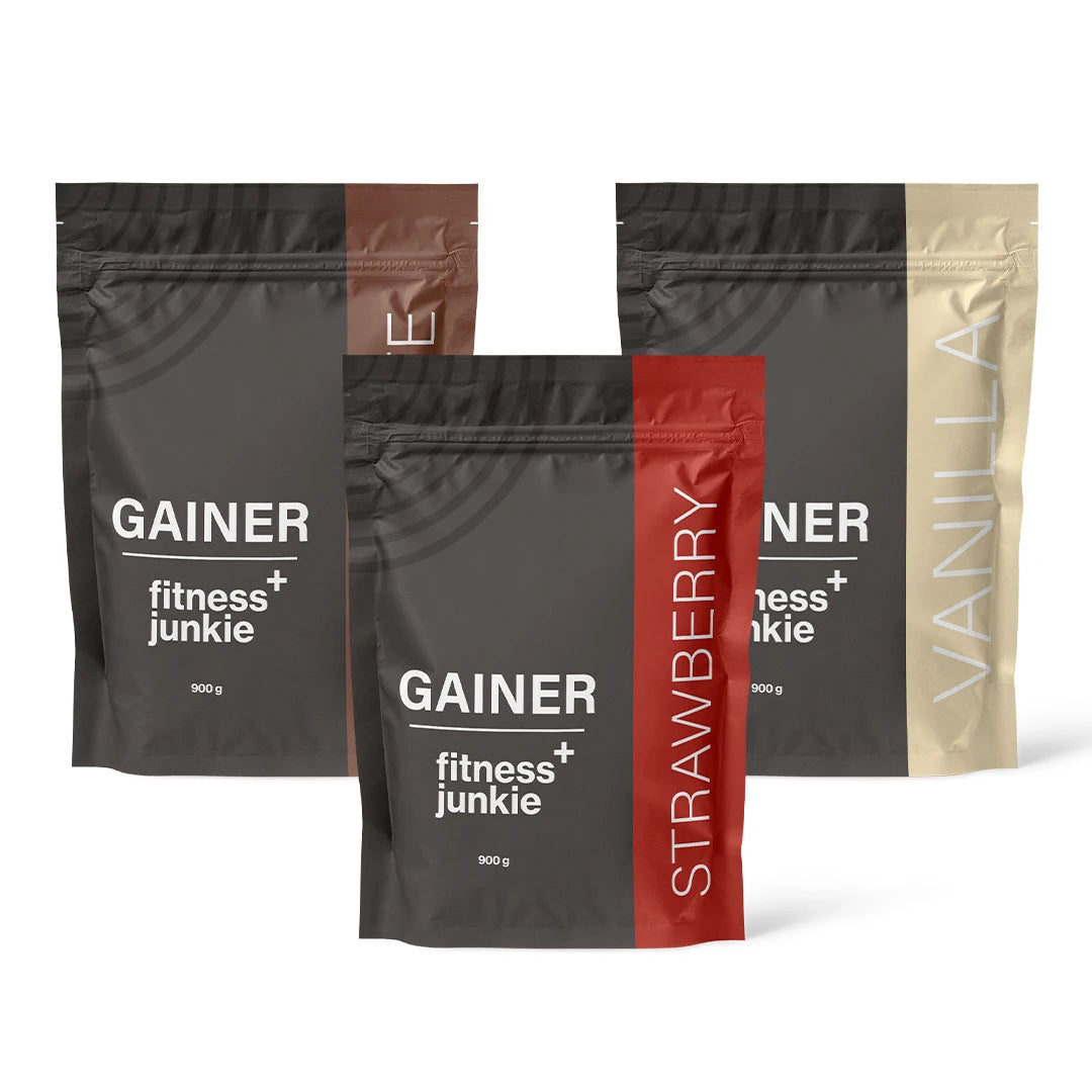3 x fitnessjunkie Gainer 900 g mustissa pusseissa, joiden yksityiskohdat viittaavat suklaa-, mansikka- ja vaniljamakuihin.