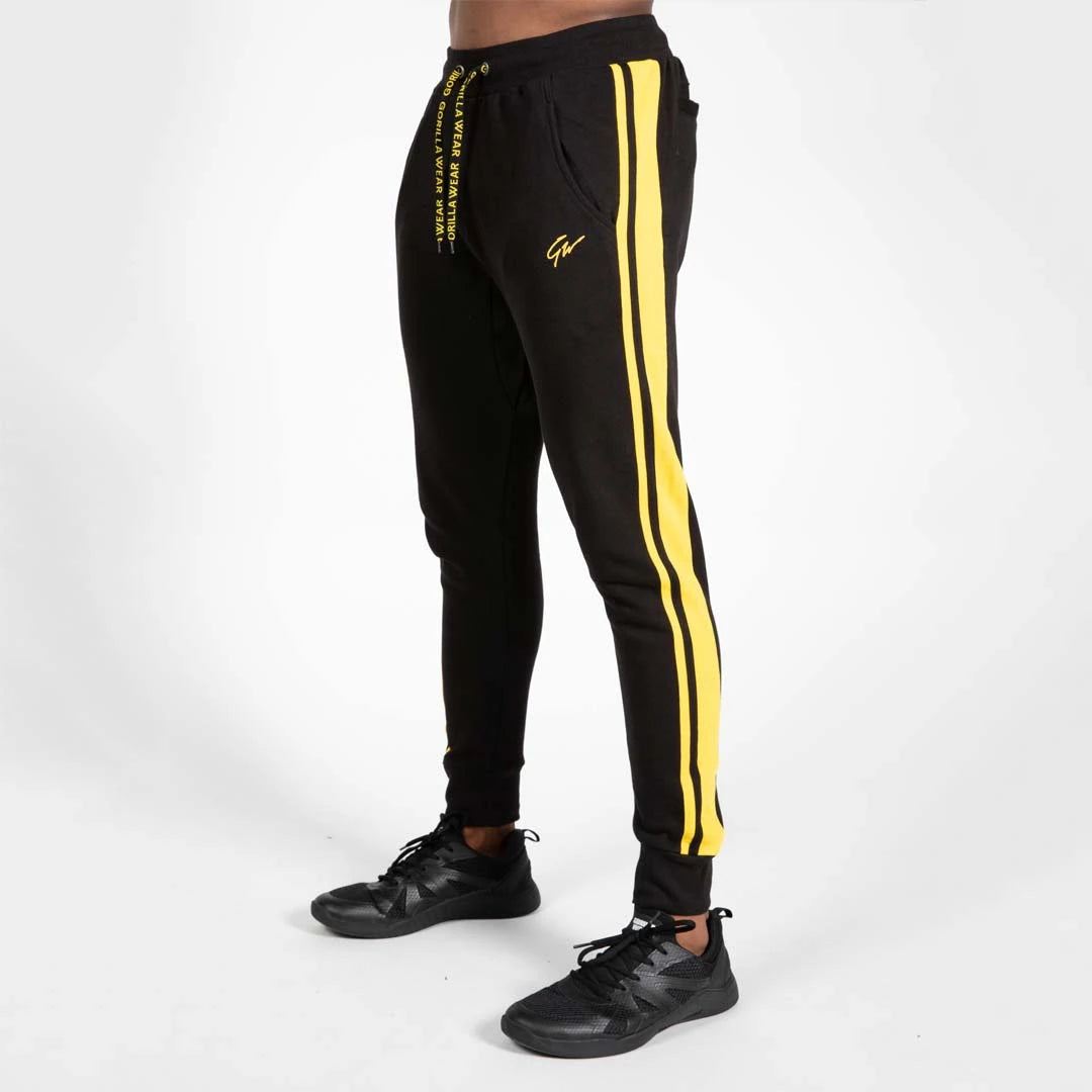 Gorilla Wear Banks Pants Black/Yellow, mustat treenihousut keltaisilla raidoilla, brodeeratulla logolla ja tekstinauhoilla., kuva 3/8