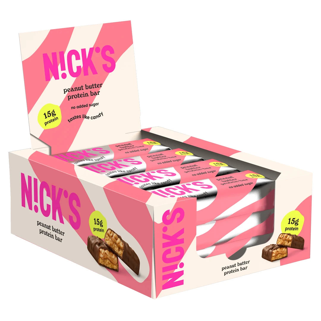 12 x NICKS Soft bar 50 g Peanut Butter vaaleanpunavalkoisessa laatikossa, jonka sisällä on yhteensopivia pakkauksia.
