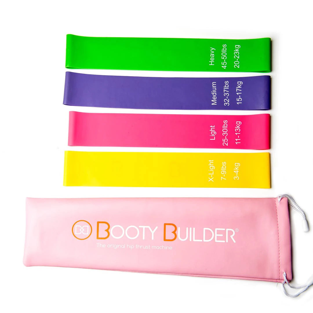 Neljä eriväristä Booty Builder Mini Bands Pink 4-Pack -treeninauhaa ja kätevä vaaleanpunainen säilytyspussi.