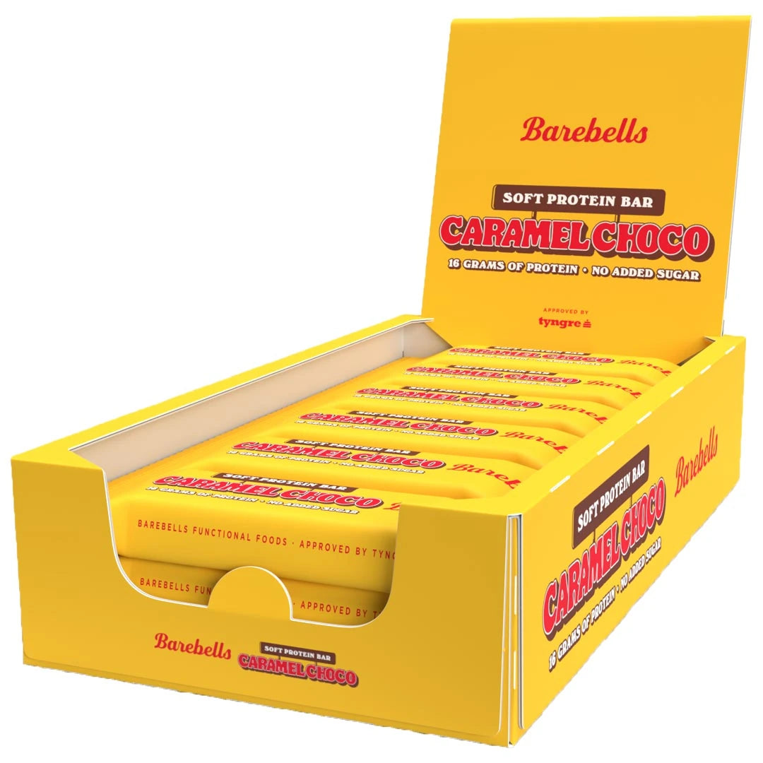 12 x Barebells Protein Bar 55 g Caramel Choco avoimessa keltaisessa esittelylaatikossa punaisilla yksityiskohdilla.