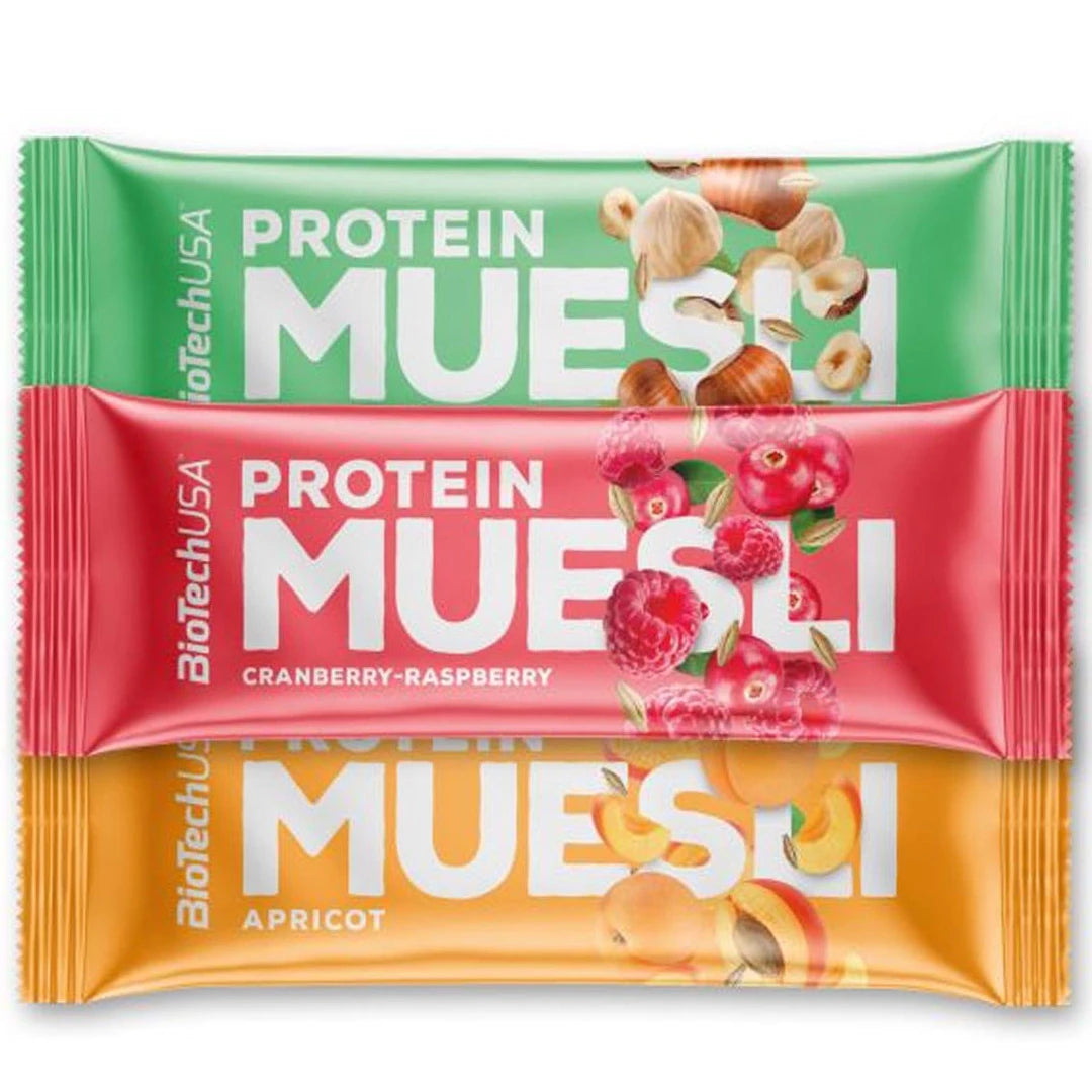 Kolme värikästä BioTechUSA Protein Muesli Bar 30 g -patukkaa päällekkäin: hasselpähkinä, karpalo-vadelma ja aprikoosi.