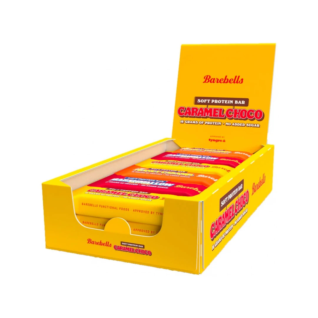 12 x Barebells Soft / Protein Bar Mixlåda 55 g avoimessa keltaisessa esittelylaatikossa, joka on täytetty eri makuisilla proteiinipatukoilla.